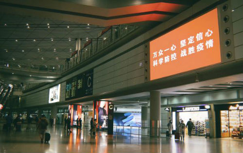 首都机场大屏幕滚动播放抗击疫情的红色标语