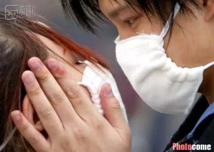 2003年4月22日，一对戴口罩的情侣在北京火车站相拥